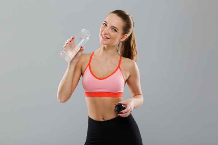 This image has an empty alt attribute; its file name is portrait-smiling-young-sports-girl-holding-water-bottle-1.jpg